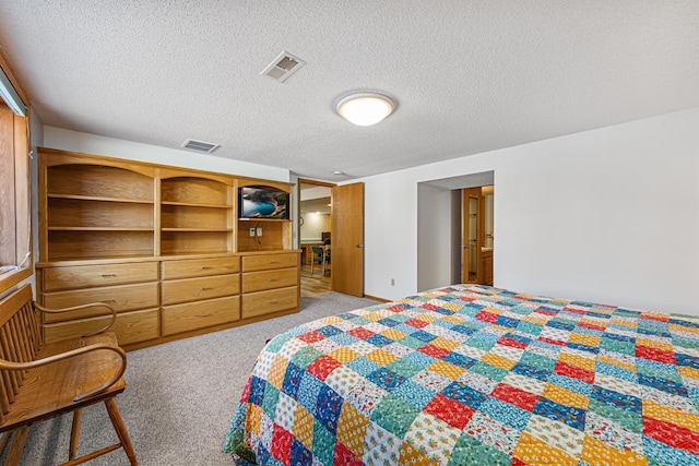 bedroom featuring visible vents, a textured ceiling, and light colored carpet