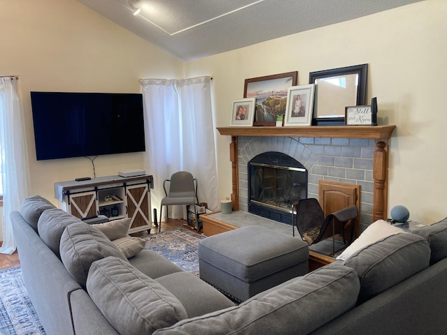 living room with vaulted ceiling, wood finished floors, and a glass covered fireplace