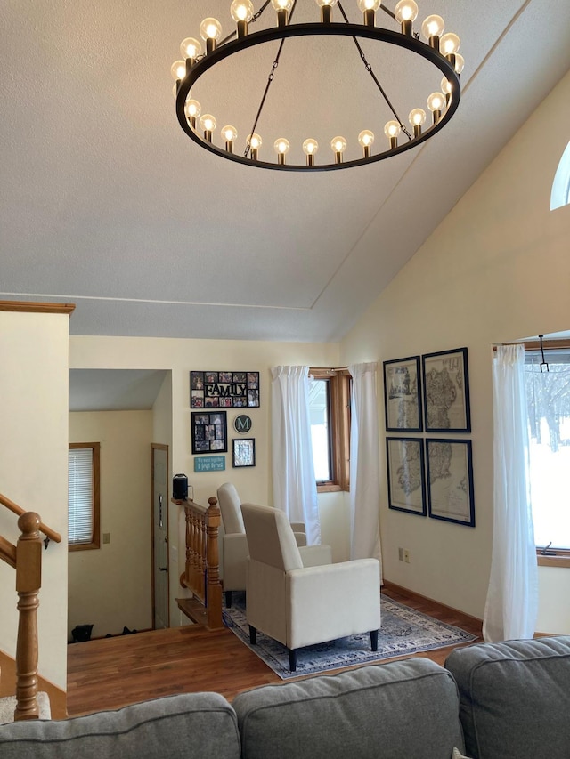 living area featuring lofted ceiling, wood finished floors, and stairs