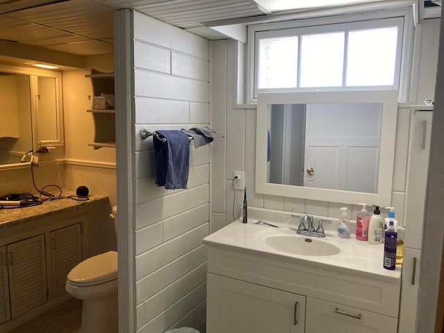 bathroom with wainscoting, vanity, and toilet