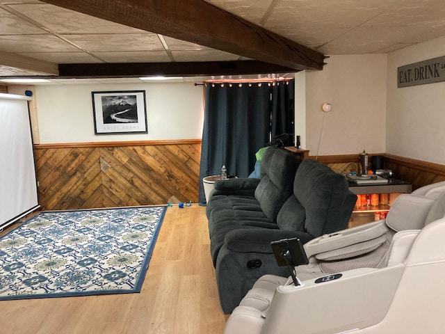 living room with wood walls, wood finished floors, and wainscoting