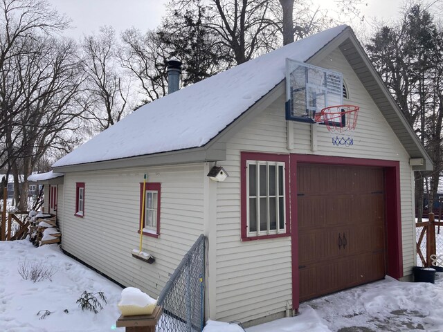 snow covered garage featuring a garage
