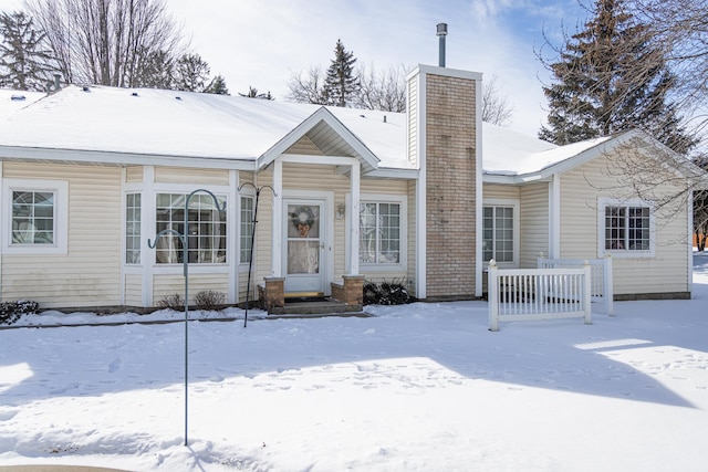 view of front of home with entry steps and a chimney