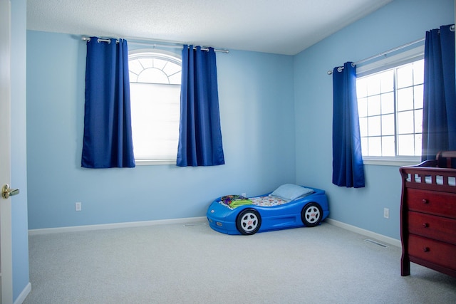 carpeted bedroom with visible vents and baseboards