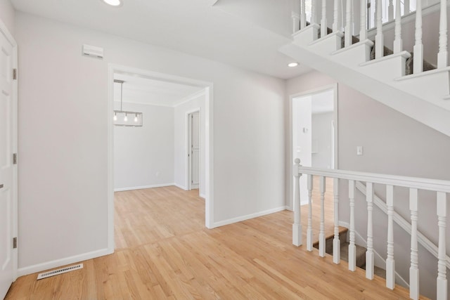 corridor featuring recessed lighting, wood finished floors, visible vents, baseboards, and stairway