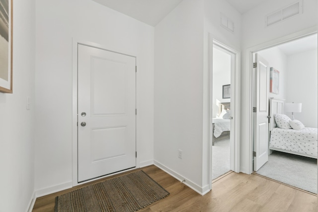 entrance foyer featuring wood finished floors, visible vents, and baseboards