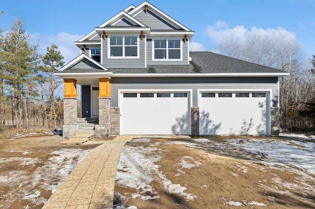 view of front of house with stone siding, driveway, and a shingled roof