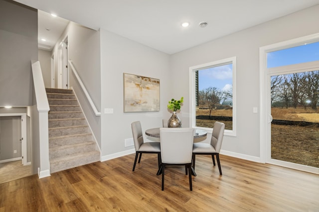 dining room featuring stairs, wood finished floors, and baseboards