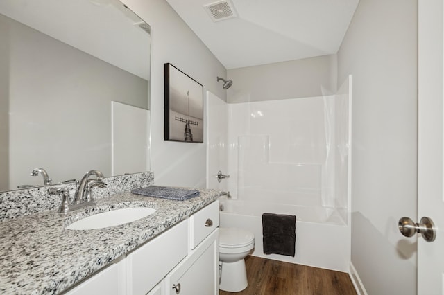 full bath featuring visible vents, toilet, vanity, wood finished floors, and shower / bathtub combination