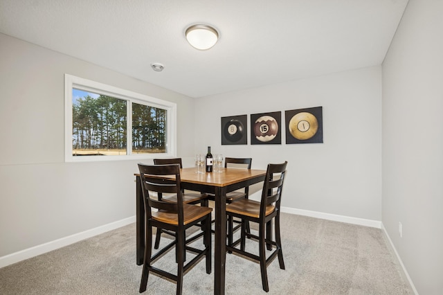 dining space featuring baseboards and carpet flooring