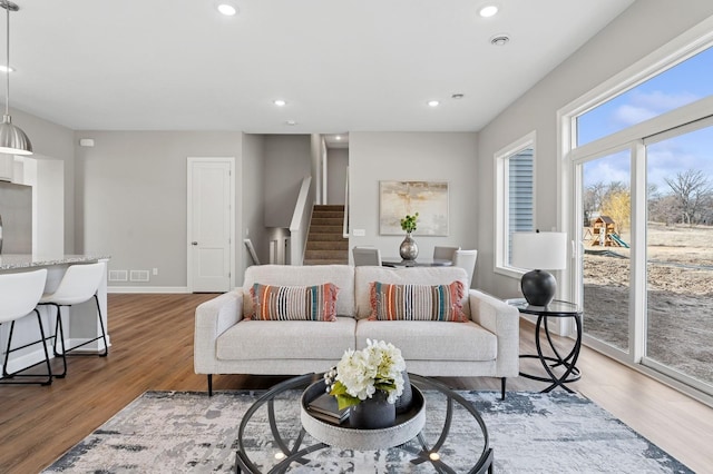 living room featuring recessed lighting, stairs, and wood finished floors