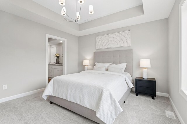 bedroom with a tray ceiling, carpet flooring, and baseboards