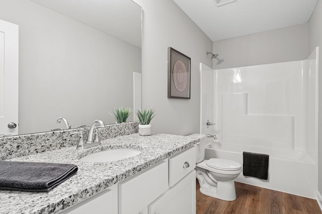 bathroom with vanity, wood finished floors, visible vents, bathing tub / shower combination, and toilet