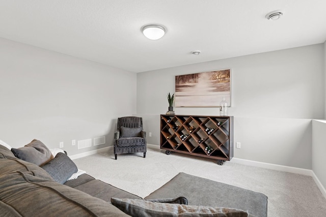 living area featuring visible vents, baseboards, and carpet