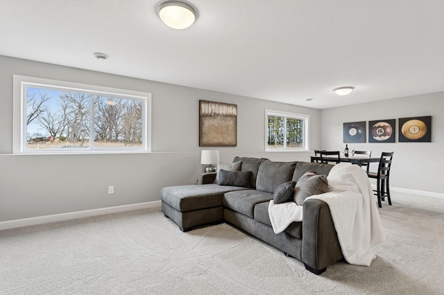 living area with baseboards and light carpet