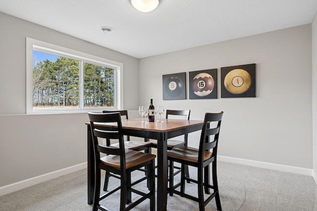 carpeted dining area featuring baseboards