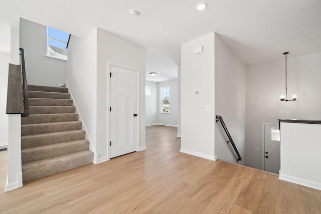 interior space with an inviting chandelier, wood finished floors, and baseboards