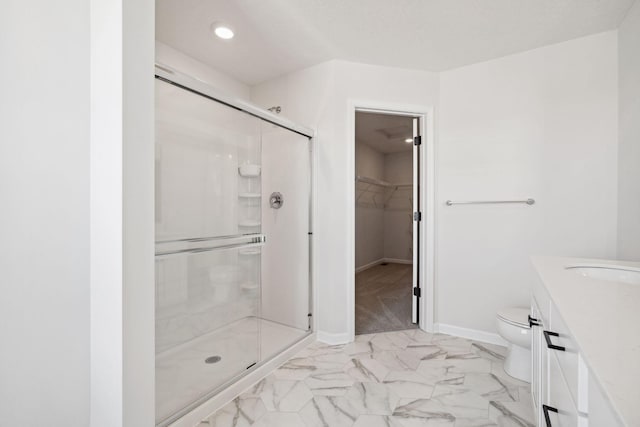 full bathroom featuring toilet, baseboards, marble finish floor, a shower stall, and a walk in closet