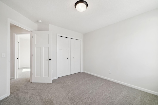 unfurnished bedroom featuring a closet, carpet flooring, and baseboards