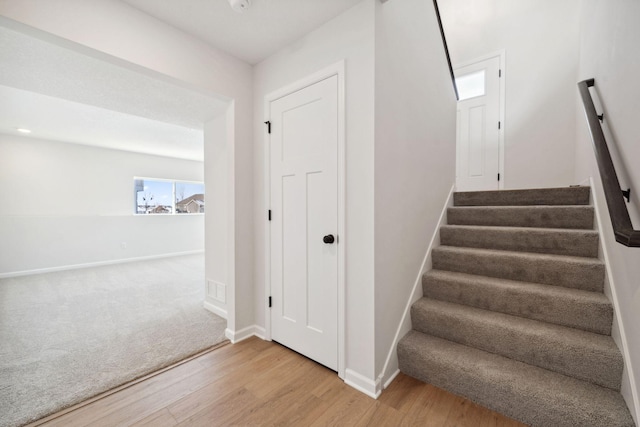 stairs with baseboards and wood finished floors