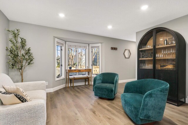 living area featuring recessed lighting, baseboards, and wood finished floors