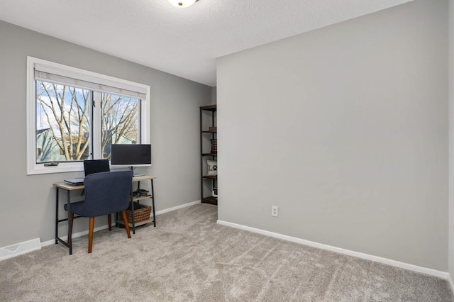 carpeted office space featuring a textured ceiling, visible vents, and baseboards