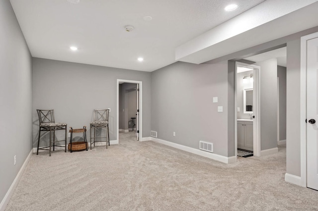 living area with carpet floors, recessed lighting, visible vents, and baseboards