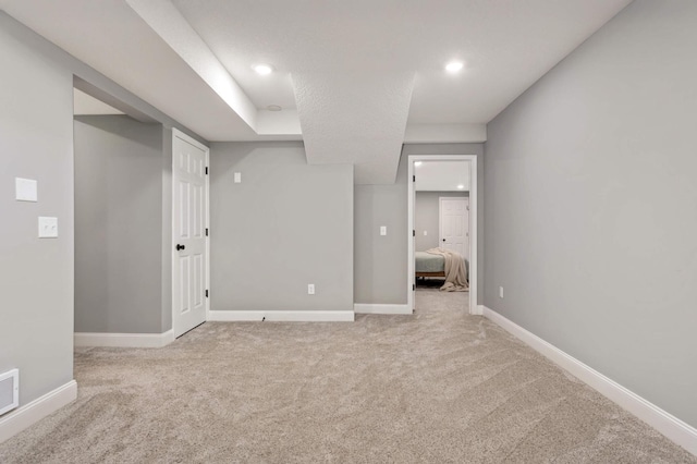 carpeted spare room featuring recessed lighting, visible vents, and baseboards