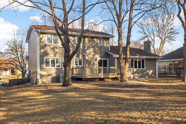 rear view of house featuring central AC, a chimney, fence, and a wooden deck