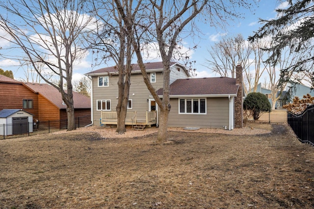 back of house featuring a chimney, a fenced backyard, and a wooden deck