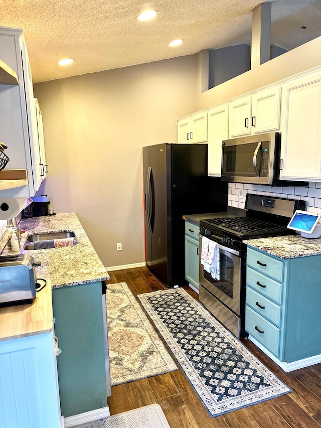 kitchen with white cabinets, dark wood-style floors, tasteful backsplash, and stainless steel appliances