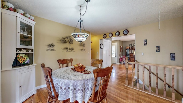 dining space featuring light wood-type flooring and baseboards