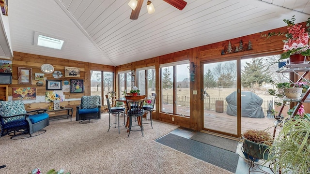 sunroom / solarium with lofted ceiling, wooden ceiling, and a ceiling fan