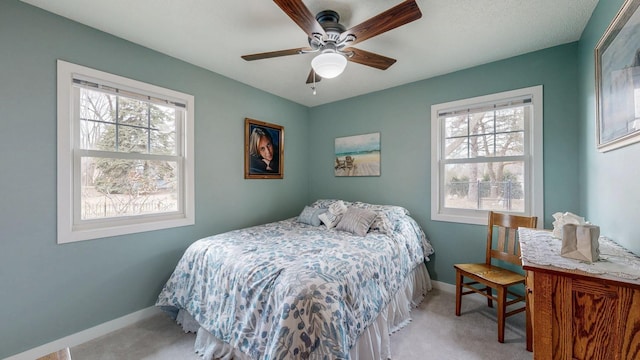 bedroom featuring light carpet, multiple windows, and baseboards