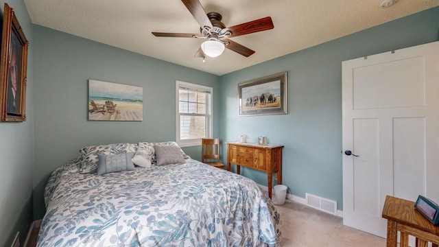 bedroom featuring baseboards, ceiling fan, visible vents, and light colored carpet