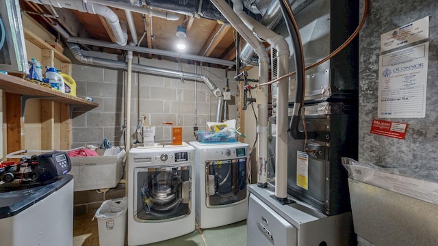 washroom with laundry area, washer and clothes dryer, and a sink