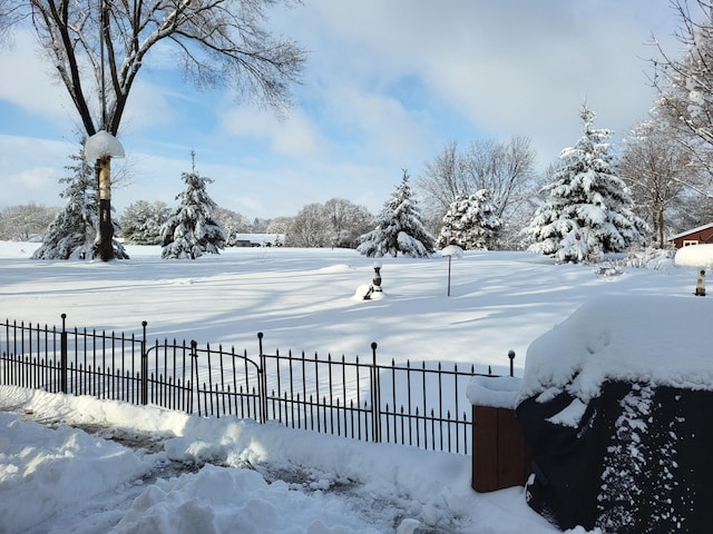 yard layered in snow featuring fence