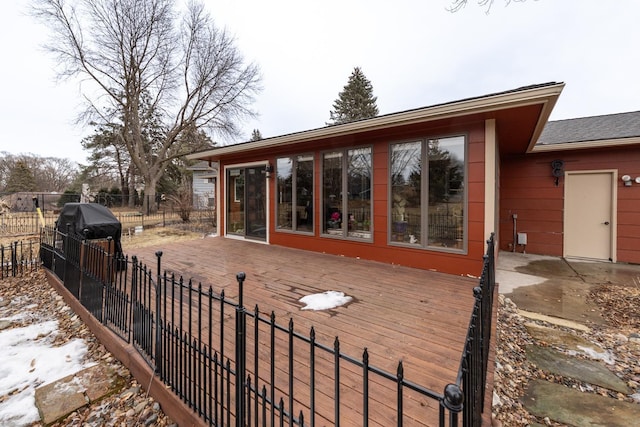 deck featuring area for grilling, fence, and a sunroom