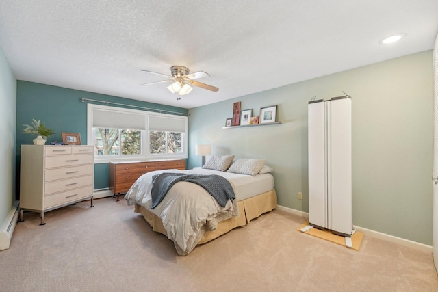 bedroom featuring light carpet, a textured ceiling, a ceiling fan, and baseboards