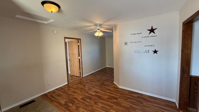 empty room with dark wood-style flooring, visible vents, ceiling fan, and baseboards