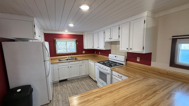 kitchen featuring white appliances, a sink, white cabinetry, and a healthy amount of sunlight