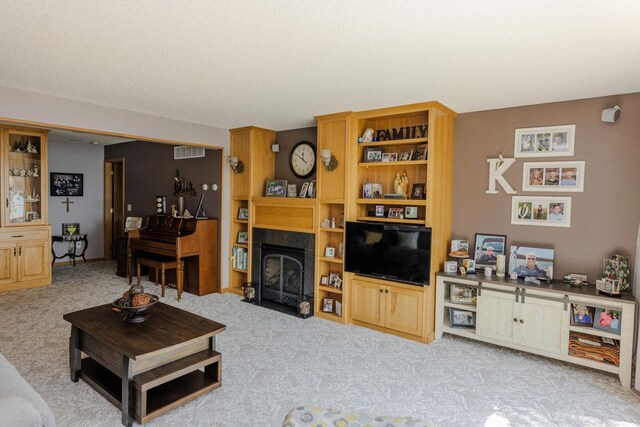 living room featuring a fireplace with flush hearth, visible vents, and light colored carpet