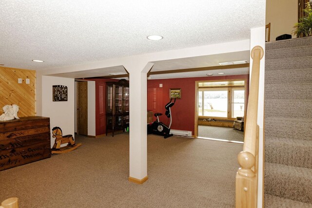 workout area with carpet, visible vents, wood walls, and a textured ceiling