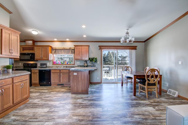 kitchen with visible vents, a chandelier, light countertops, black appliances, and a sink