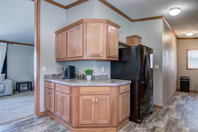 kitchen featuring black fridge, wood finished floors, crown molding, and light countertops