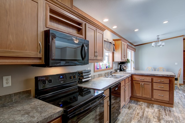 kitchen with ornamental molding, light wood-style flooring, a peninsula, black appliances, and a sink