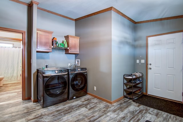 washroom with cabinet space, washer and dryer, light wood-style flooring, and ornamental molding