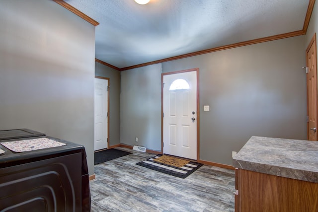 entryway with visible vents, crown molding, baseboards, wood finished floors, and a textured ceiling