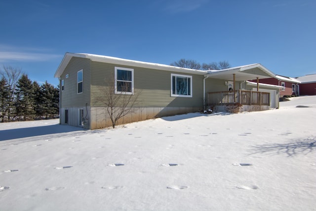 snow covered back of property featuring a porch