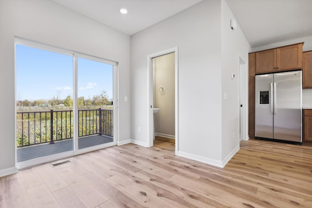 kitchen featuring baseboards, stainless steel refrigerator with ice dispenser, visible vents, and light wood-style floors